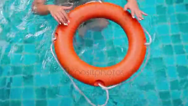 Tocco femminile mano e twist salvagente in piscina blu acqua — Video Stock