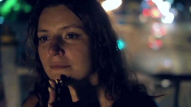 Gadis muda dalam kaos hitam di malam hari berdiri di jembatan dengan latar belakang mobil yang bergerak — Stok Video