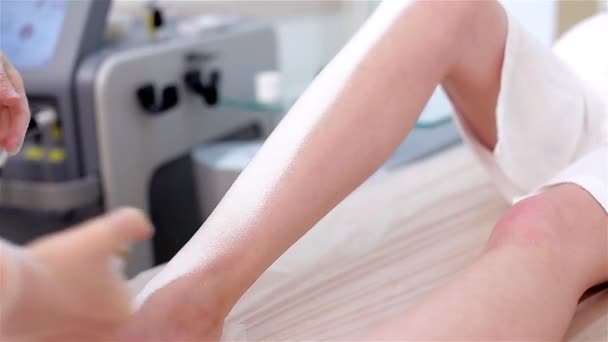 Na een laser hair removal procedure, de arts de room spray op de voet aan de patiënt — Stockvideo