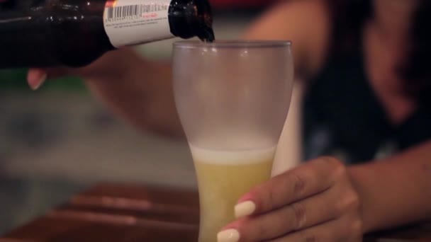Hand pours beer from a bottle into a glass — Stock Video