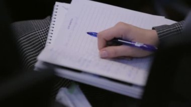 Kadın bir defter bir konferans ya da eğitim notlar alır