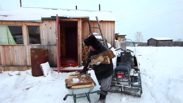 Un hombre adulto prepara madera para el invierno — Vídeo de stock