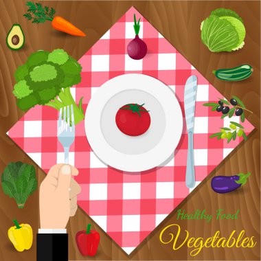 Elini tut bir brokoli bir çatalı. plaka bıçak ve çatal üzerinde bir kafes içinde kırmızı bir masa örtüsü.