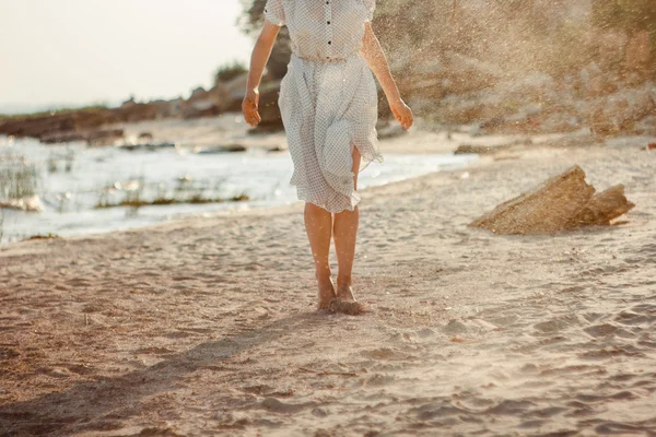Chica lanza arena a la playa — Foto de Stock