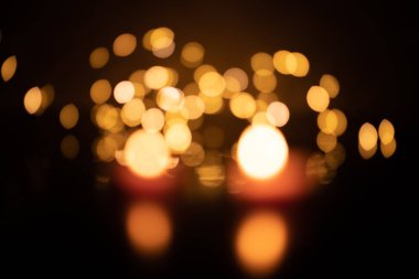 Bokeh of two candles on a background of yellow LED lights
