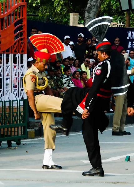 パキスタンとインド、ワガ、ラホール、パキスタン間のボーダーのフラグを下げる式で国立の制服で行進パキスタンとインドの警備員 — ストック写真