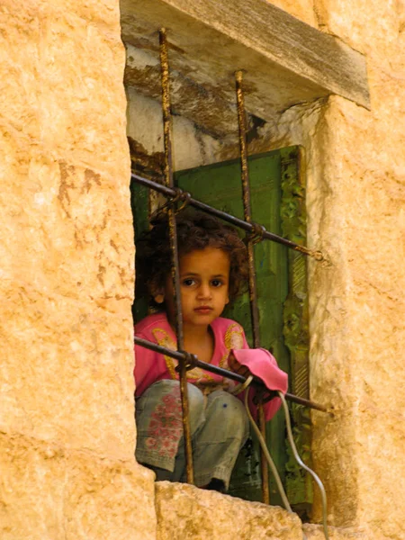 Mädchen mit Blick auf die Straße hinter dem Fenster, mahwit. jemen — Stockfoto