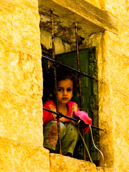 Mädchen mit Blick auf die Straße hinter dem Fenster, mahwit. jemen — Stockfoto