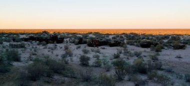 Gemi günbatımı Moynaq, Karakalpakstan, Özbekistan yakınındaki mezarlıkta Panoraması
