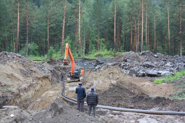 İşçiler boru hattı ormanın içinde yatıyordu.