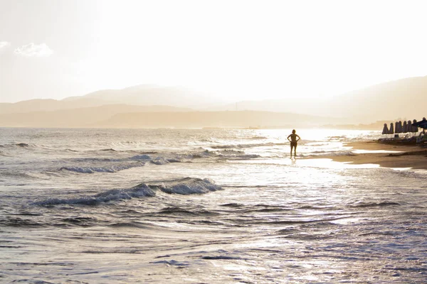 Donna ai raggi del sole nascente sulla spiaggia . — Foto Stock