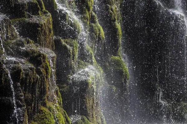 Los chorros y gotas de agua contra las rocas negras  . —  Fotos de Stock