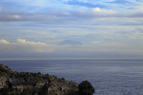 La cima del volcán sobre un fondo de cielo nublado sobre el oc — Foto de Stock