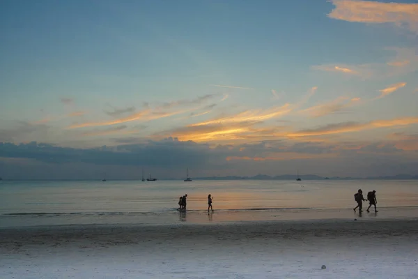 Touristen mit Rucksäcken spazieren am Sandstrand des Meeres entlang. — Stockfoto