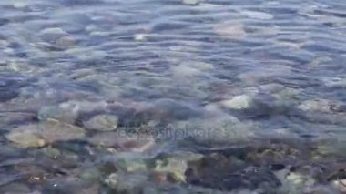 Çakıl plajı hakkında şeffaf deniz su sıçramalarına