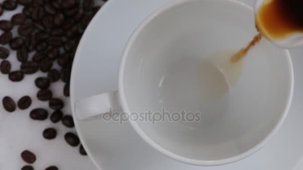 Frisch gebrühter Kaffee wird in eine weiße Tasse gegossen. — Stockvideo