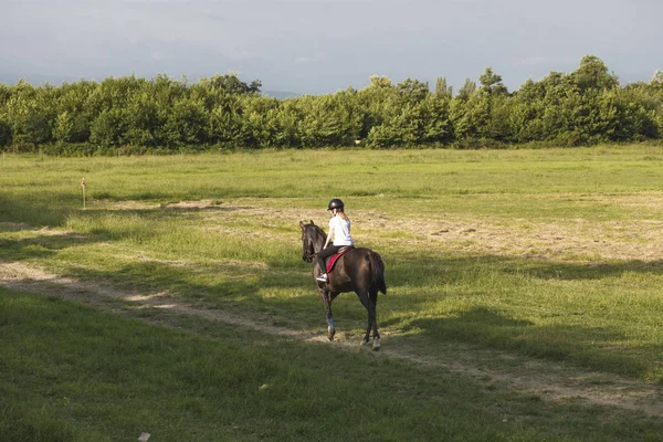 Bir kız bir ülke yolda ata biniyor.