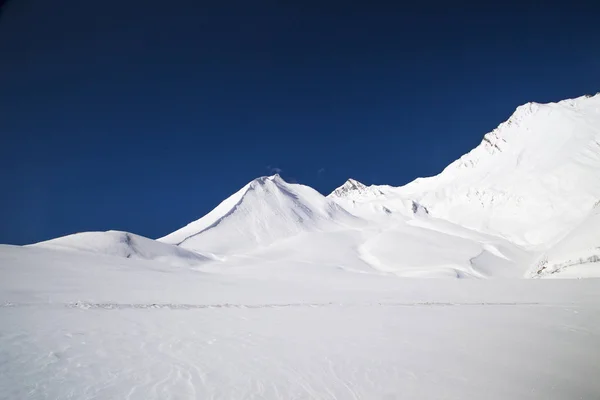 Montañas nevadas en el fondo del cielo azul oscuro . —  Fotos de Stock