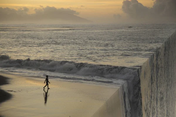 Silueta de un niño en la playa al atardecer . —  Fotos de Stock