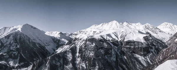 Picos montañosos nevados. Cielo azul en un día claro de invierno —  Fotos de Stock