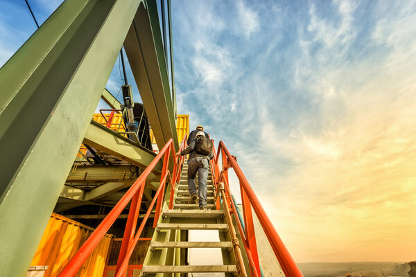 men standing near bucket wheel excavator