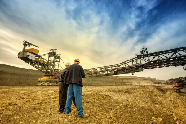 Hombres de pie cerca de la excavadora de rueda de cubo — Foto de Stock