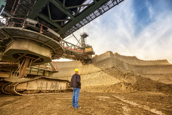 Hombre de pie cerca de la excavadora de rueda de cubo — Foto de Stock