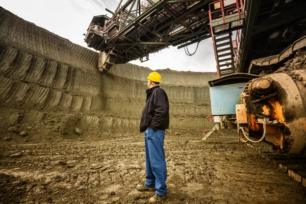 Homem de pé perto de escavadeira roda de balde — Fotografia de Stock
