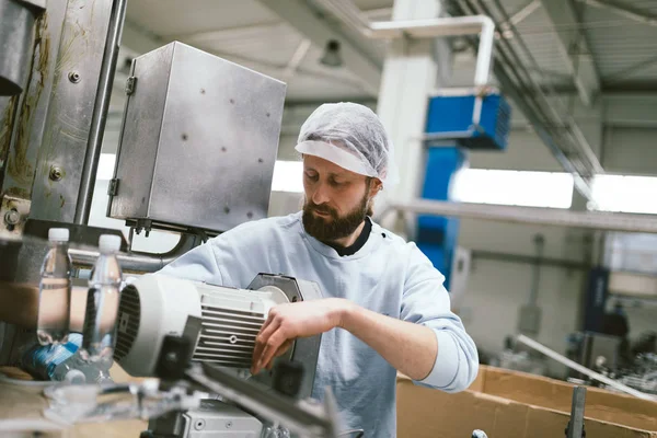 Pracovník dělá práci na robotické linky — Stock fotografie