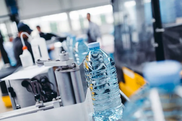 Linha de fábrica robótica água engarrafada em recipientes — Fotografia de Stock