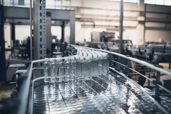 Línea de fábrica robótica embotellando agua en botellas —  Fotos de Stock