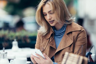  telefonu kullanan genç kadın