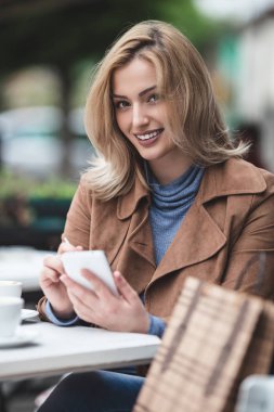  telefonu kullanan genç kadın