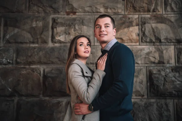 Jeune couple attrayant par mur de pierre — Photo