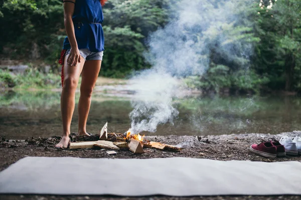 Barefoot woman standing near campfire — Stock Photo, Image