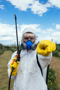 Endüstriyel tarım Tema. Püskürtme zehirli böcek ilacı veya meyve plantasyon büyüyen böcek öldürücüler dostum. Güneşli doğal sert ışık. Mavi Gökyüzü bulutlu arka planda