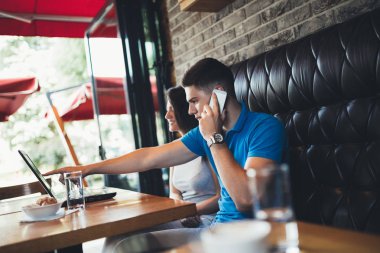 Çekici genç çift kafe restoranda iyi vakit geçiriyor. Laptop bir şey yapıyor