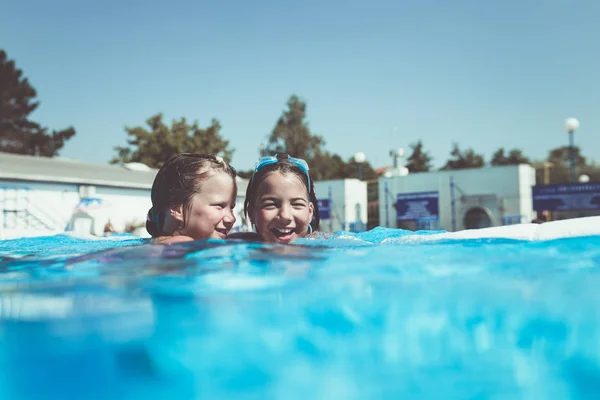 Underwater fun. Two cute little girls with goggles swimming underwater and diving in the swimming poll. Kids sport and leisure