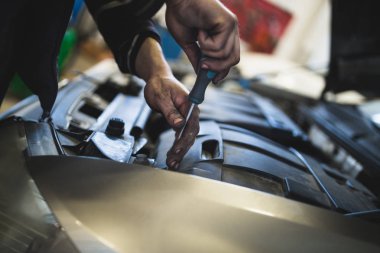 Araba servisi ve bakım yapan tanınmayan tamircinin ellerini kapat.