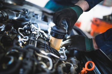 Tanınmayan makinist araba servis ve bakım yaparken ellerini kapatın. Petrol ve yakıt filtresi değiştirme