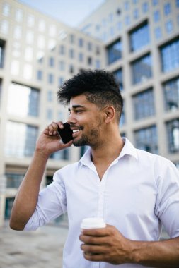 Büyük modern iş kurma gülümseyen ve cep telefonuyla konuşurken önünde duran genç Afro Amerikan yakışıklı