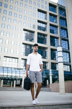 Büyük modern işletme binası önünde duran genç Afro Amerikan yakışıklı