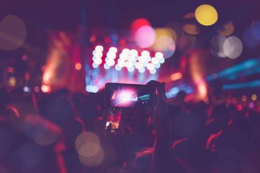 Siluetleri festival konser kalabalığın önünde parlak sahne ışıkları. Tanınmayan insanlar ve renkli etkileri