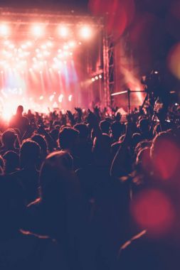 Siluetleri festival konser kalabalığın önünde parlak sahne ışıkları. Tanınmayan insanlar ve renkli etkileri