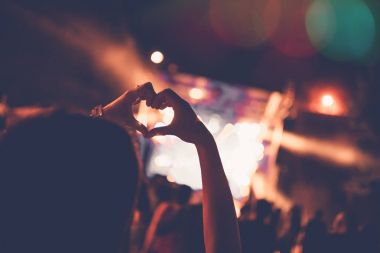 Siluetleri festival konser kalabalığın önünde parlak sahne ışıkları. Tanınmayan insanlar ve renkli etkileri