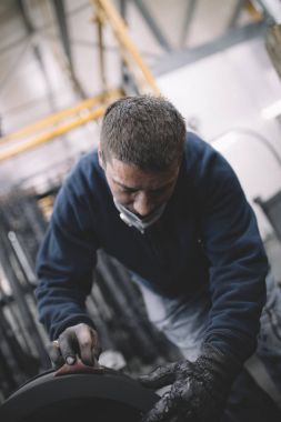 Metalurji Sanayi. Fabrika üretim ağır Pelet soba ve kazanlar için. Onun iş işçi ressam. Son derece karanlık koşulları ve görünür gürültü