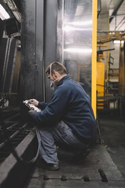 Metalurji Sanayi. Fabrika üretim ağır Pelet soba ve kazanlar için. Onun iş işçi ressam. Son derece karanlık koşulları ve görünür gürültü