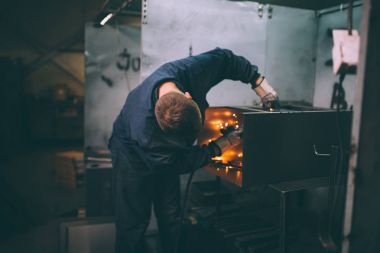 Metalurji Sanayi. Fabrika üretim ağır Pelet soba ve kazanlar için. Onun iş işçi ressam. Son derece karanlık koşulları ve görünür gürültü