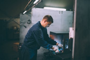 Metalurji Sanayi. Fabrika üretim ağır Pelet soba ve kazanlar için. Onun iş işçi ressam. Son derece karanlık koşulları ve görünür gürültü