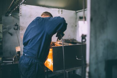 Metalurji Sanayi. Fabrika üretim ağır Pelet soba ve kazanlar için. Onun iş işçi ressam. Son derece karanlık koşulları ve görünür gürültü